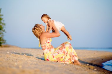 Kumsalda oynarken kızı olan anne