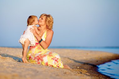 Kumsalda oynarken kızı olan anne