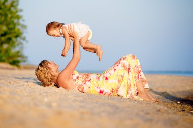 Kumsalda oynarken kızı olan anne