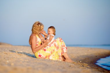 Kumsalda oynarken kızı olan anne