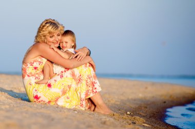 Kumsalda oynarken kızı olan anne