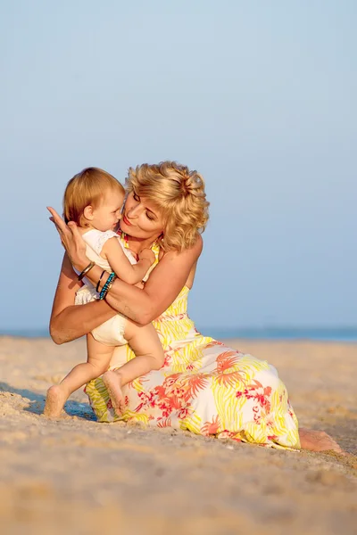 Mama met een dochter spelen op het strand — Stockfoto