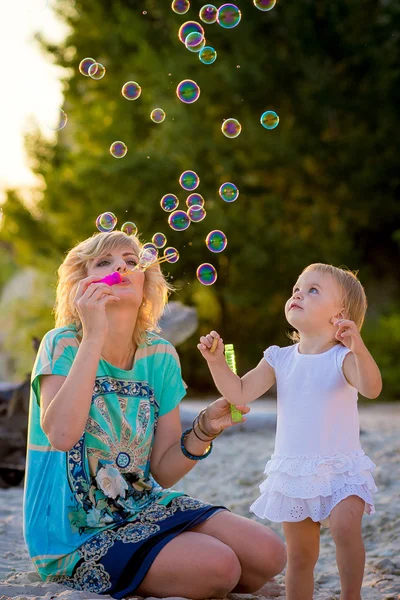 Mama met een dochter spelen op het strand — Stockfoto