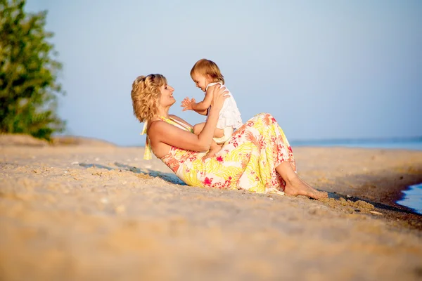 Mama met een dochter spelen op het strand — Stockfoto