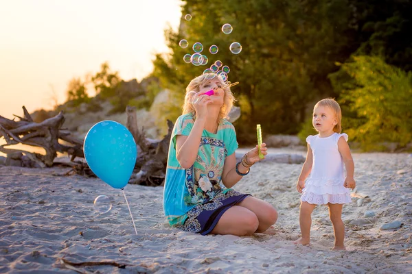 Mama met een dochter spelen op het strand — Stockfoto