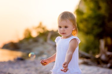 Kumsalda yürüyen kız.