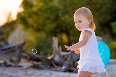 Kumsalda yürüyen kız.