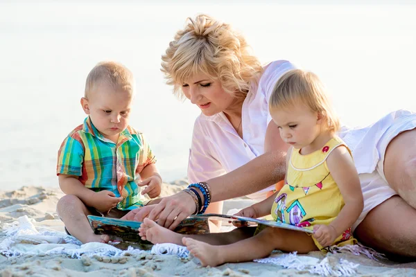 Mutter mit zwei Kindern am Strand — Stockfoto