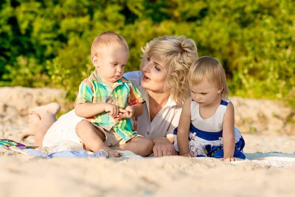 Mutter mit zwei Kindern am Strand — Stockfoto