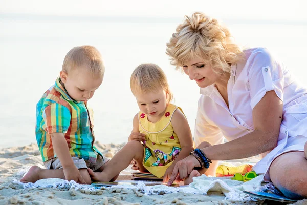 Mutter mit zwei Kindern am Strand — Stockfoto