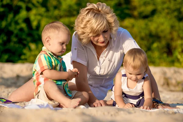 Mutter mit zwei Kindern am Strand — Stockfoto