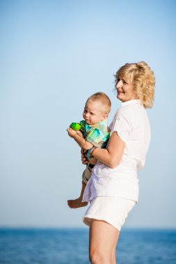 Sahilde yürüyüş yürümeye başlayan çocuk ile anne.