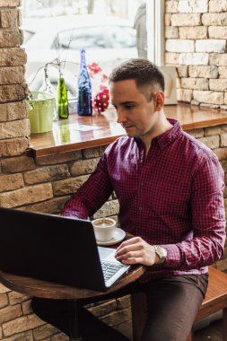 adam kafede çalışan dizüstü bilgisayar ile