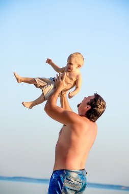 Baba oğlu ile kumsalda oynarken.