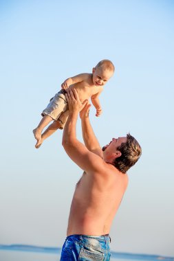 Baba oğlu ile kumsalda oynarken.