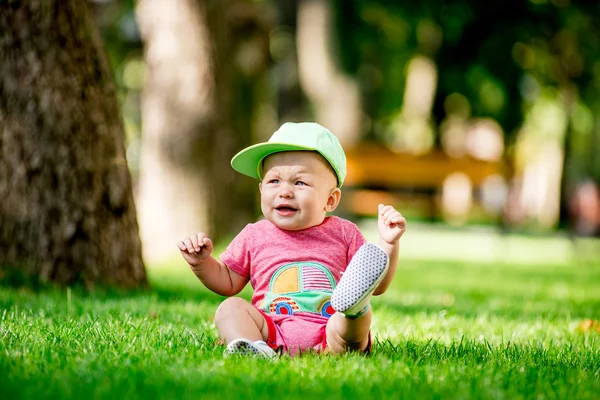 Menino sentado na grama — Fotografia de Stock