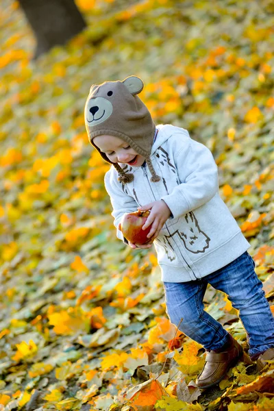 Весела дитина з яблуком восени — стокове фото