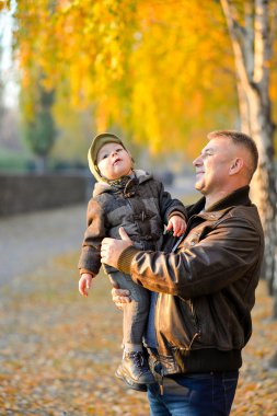 Sonbaharda oğlu parkta oynarken baba.