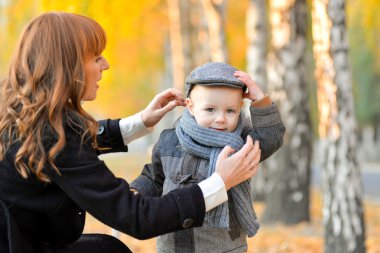Mother with baby in the park in autumn. clipart