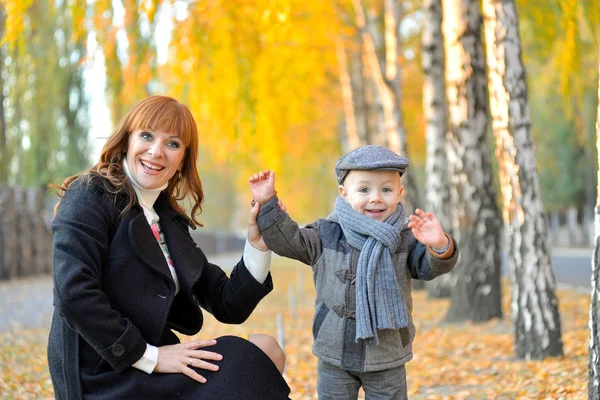 Moeder met baby in het park in het najaar. — Stockfoto