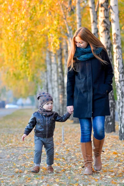 Moeder met kinderen in de herfst — Stockfoto