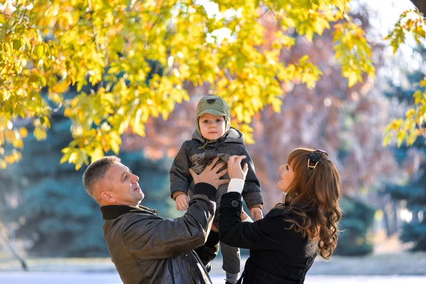 Niño en los brazos de mamá y papá — Foto de Stock