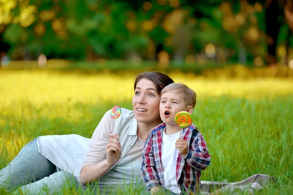 Mutter mit Baby im Park isst Süßigkeiten. — Stockfoto
