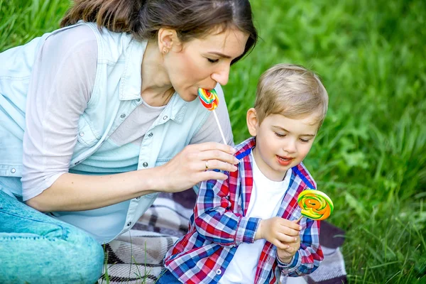 Mutter mit Baby im Park isst Süßigkeiten. — Stockfoto