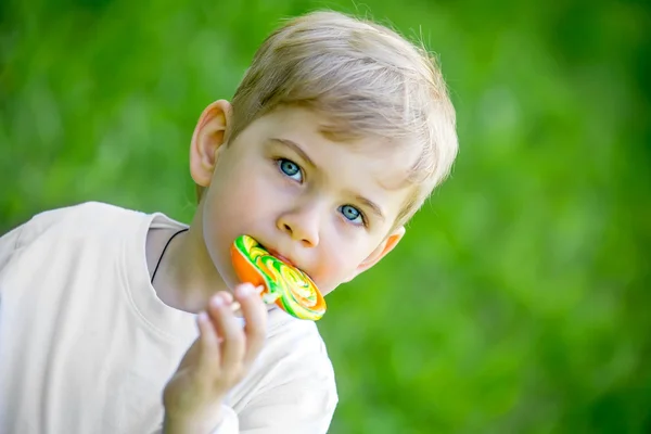 parkta bir lolipop yemek yürümeye başlayan çocuk