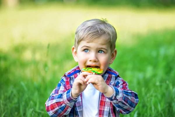 parkta bir lolipop yemek yürümeye başlayan çocuk