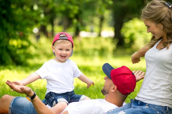 Niño pequeño con mamá y papá jugando en el parque . —  Fotos de Stock