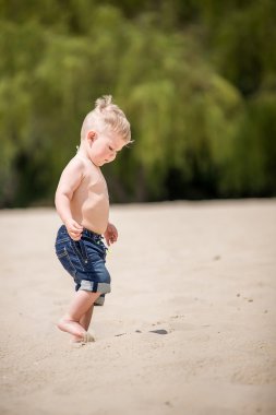 Kumsalda yürüyen çocuk.