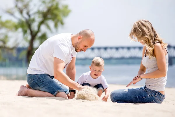 Baby mit Eltern spielt am Strand — Stockfoto