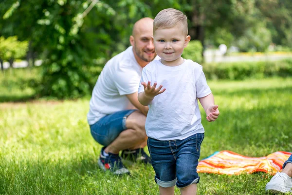 Jongetje met vader en moeder spelen in het park. — Stockfoto