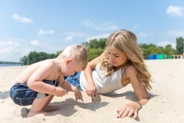 Genç ailesi ile sahilde dinlenme bir yürümeye başlayan çocuk.