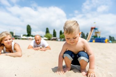 Genç ailesi ile sahilde dinlenme bir yürümeye başlayan çocuk.