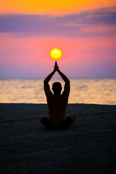 Uomo pratica yoga sulla spiaggia, il mare . — Foto Stock