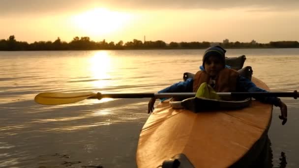 Вечірня поїздка на байдарці вздовж річки восени. Активний спосіб життя дитини в сім'ї . — стокове відео