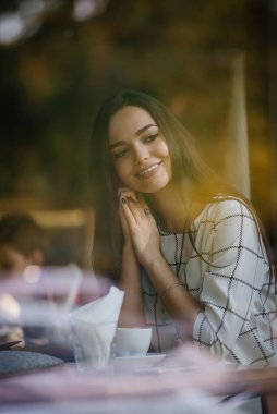 Müslümanların Avrupa 'ya entegrasyonu. Genç ve güzel Müslüman kız Avrupa kültürünü benimsiyor. Genç Müslüman bir kadın kafeteryada tesettürsüz oturuyor..