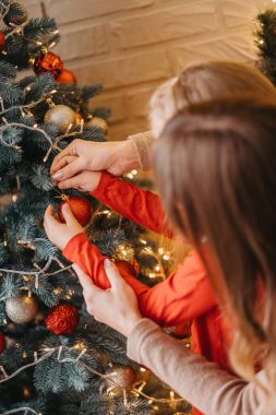 Anne ve kızı Noel ağacını birlikte süsler. Geleneksel ebeveynlik.