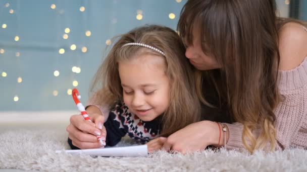 Moeder Helpt Haar Dochter Schrijven Een Brief Aan Kerstman Buurt — Stockvideo