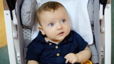 Çocuk bebek arabasında oturur ve etraftaki her şeyi inceler..