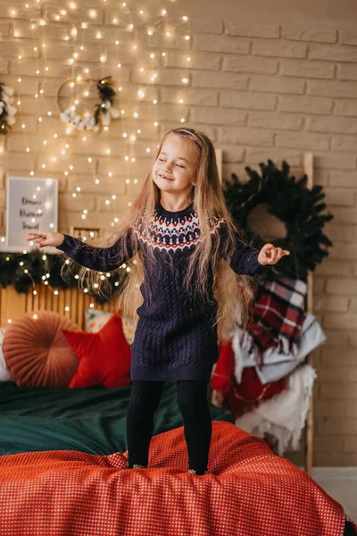 메리 크리스마스 컨셉이야. 아이는 집에 있는 크리스마스 트리 근처에서 즐겁게 춤을 추고 있다. 집에서의 메리 크리스마스 축하. — 스톡 사진