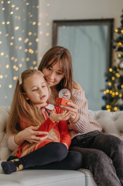 Anne ve kızı evde birlikte oturup Noel sihrini bekliyorlar. Noel arifesinde annemle.