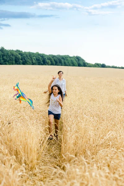 Moeder Dochter Rennen Een Tarweveld Met Een Vlieger Zomer Gelukkige — Stockfoto