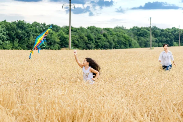 Moeder Dochter Rennen Een Tarweveld Met Een Vlieger Zomer Gelukkige — Stockfoto