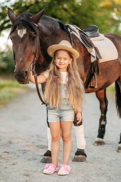 Przyjaźń dziecka z koniem. Leczenie autyzmu koniem. Interakcja dziewczyny z autyzmem i koniem. Chodzenie z dzieckiem z koniem jesienią. — Zdjęcie stockowe