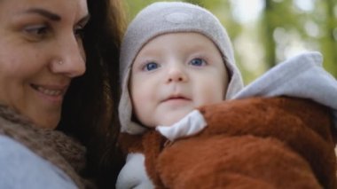 Anne ve bebek sonbaharda parkta eğleniyorlar..