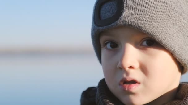 Passeggiata sulle rive del lago Michigan. Un ragazzo cammina all'inizio della primavera vicino al lago. Passeggiata primaverile con un bambino vicino al fiume. — Video Stock