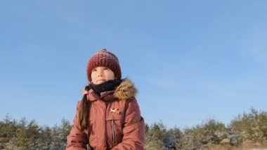 Mutlu bir çocukluk. Güneşli ve soğuk bir günde, karlı bir ormanda kış eğlencesi. Kız neşeyle kar fırlatıyor..